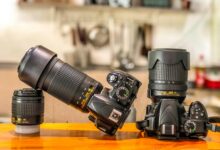 Close-up of DSLR cameras and lenses on a wooden table indoors, ideal for photography enthusiasts.