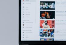 Person browsing YouTube videos on a laptop, showcasing modern technology and online content.